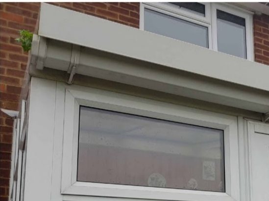 A white fascia and gutter above a window after cleaning by A.W. Windows
