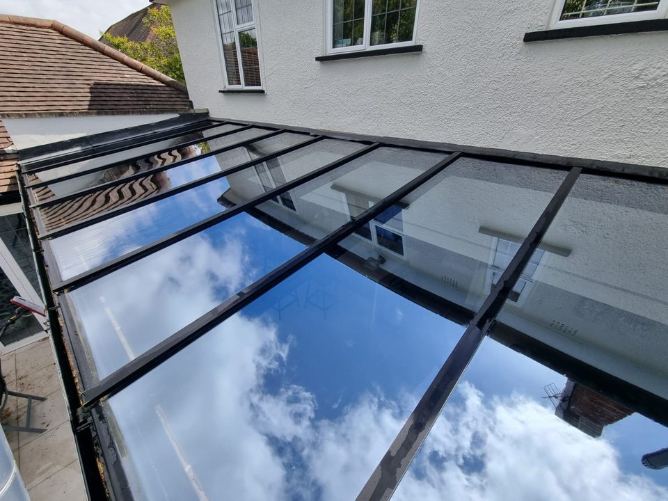 A glass conservatory roof after cleaning, reflecting the sky